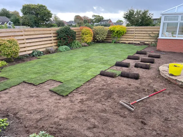Fresh turf partially laid with rolls ready for the remaining ground